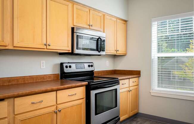 A kitchen with wooden cabinets and a black stove top oven.
