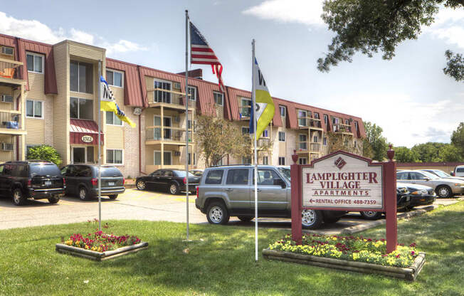 Exterior shot of apartment building with sign that says "Lamplighter Village"
