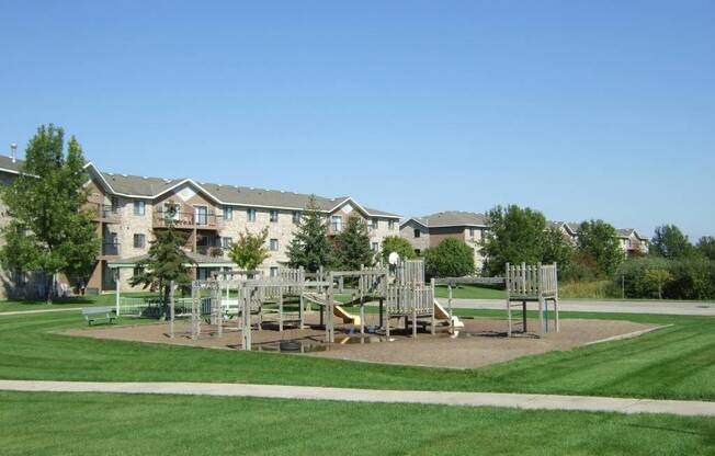 an image of a playground with an apartment building in the background