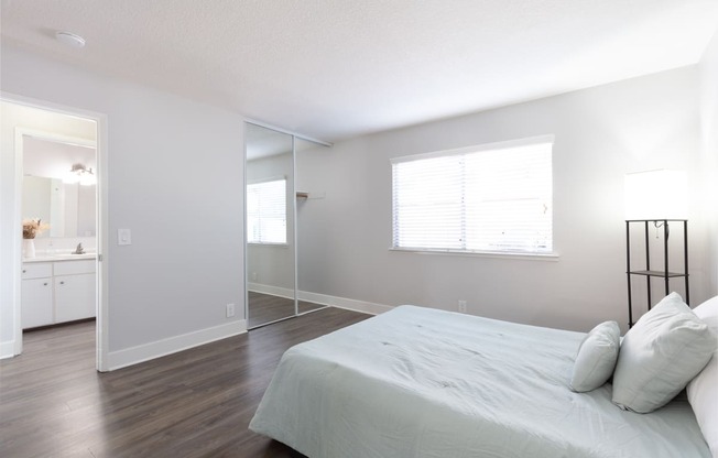 an empty bedroom with a bed and a bathroom