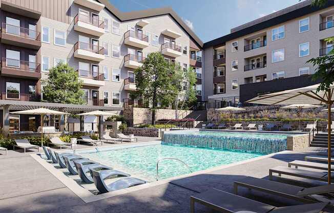 A large swimming pool surrounded by lounge chairs and umbrellas in front of apartment buildings.