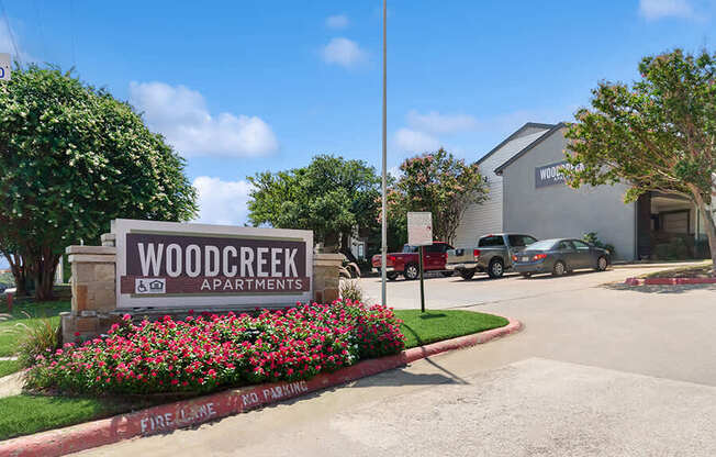Community Monument Sign and Landscape at Woodcreek Apartments located in Arlington, TX.