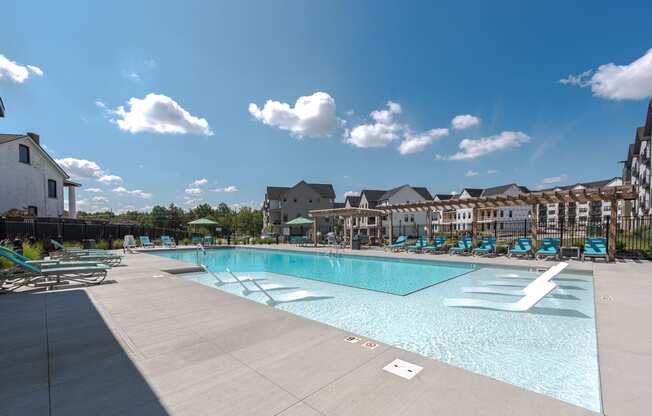 a swimming pool with lounge chairs and a building in the background