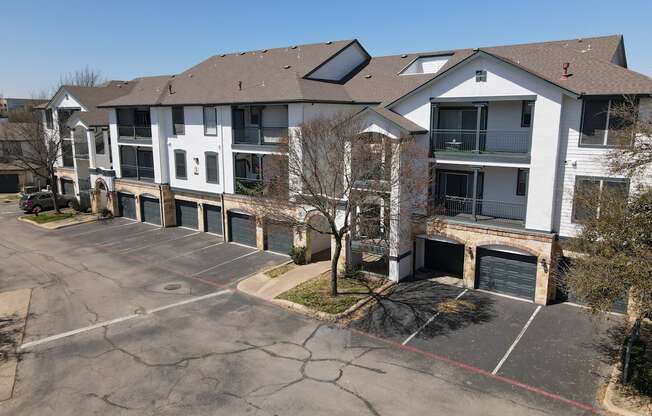 A large white building with a parking lot in front.