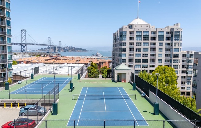 A tennis court is located on the roof of a building.