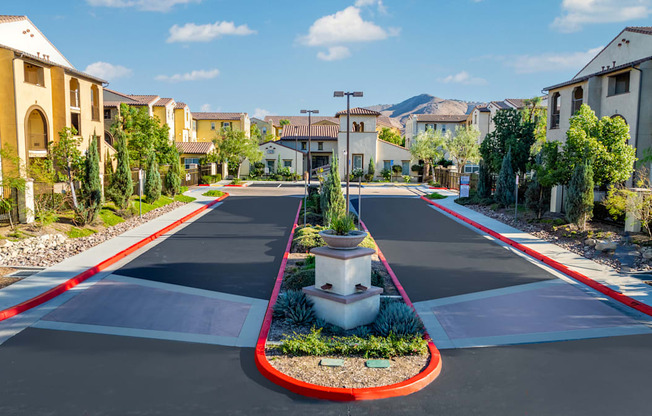 an empty street in a neighborhood with houses and plants on a cross walk