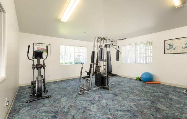 a gym with exercise equipment in the corner of a room