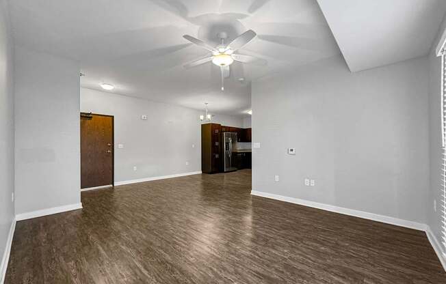 an empty living room with a ceiling fan