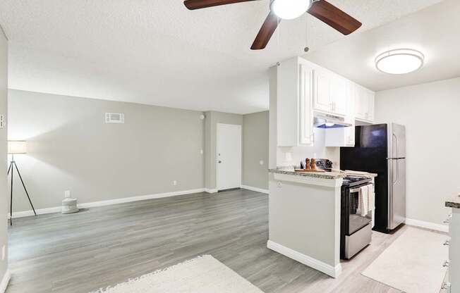 A kitchen with a refrigerator, oven, and microwave.