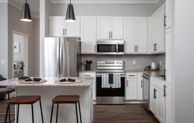 a kitchen with white cabinets and stainless steel appliances at The Edison at Maple Grove, Maple Grove, MN 55129