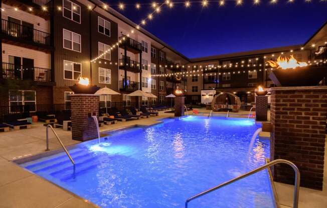 A lit up pool area at night.