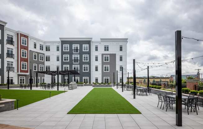 a row of apartment buildings with lawns and chairs