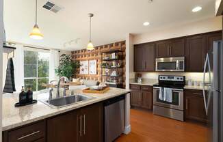 A modern kitchen with dark wood cabinets and stainless steel appliances.