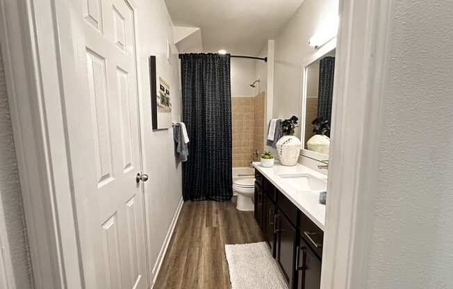 a bathroom with a shower and a sink and a toilet