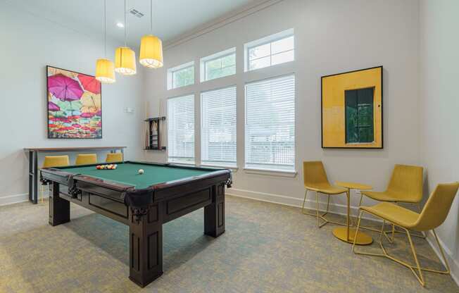 a games room with a pool table and chairs