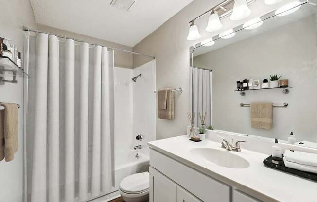 A modern bathroom with a white sink and a white toilet.