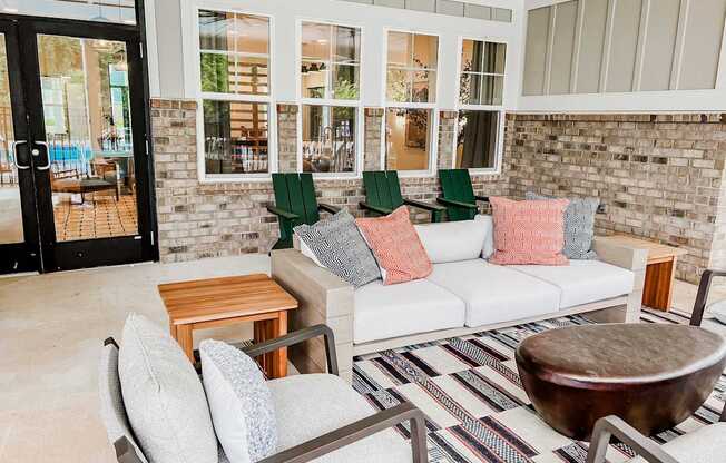 A patio with a white couch and a wooden table.