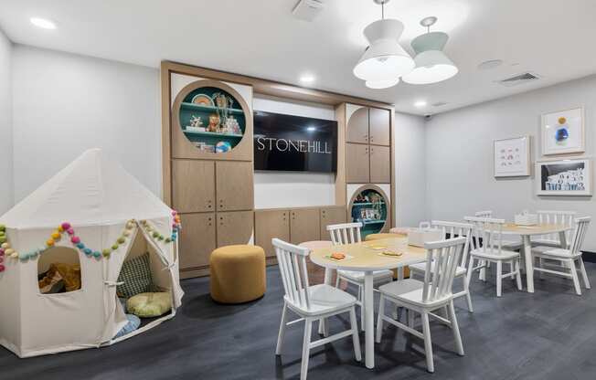 a play room with a table and chairs and a tent