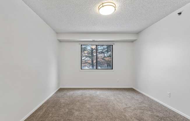 a bedroom with white walls and a large window