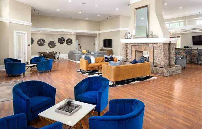 A living room with blue chairs and a fireplace.