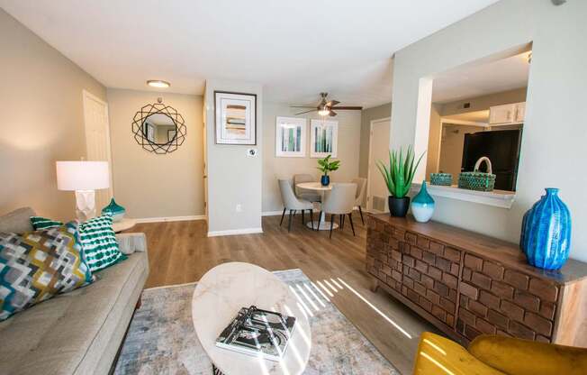 A living room with a couch, a coffee table, and a mirror.