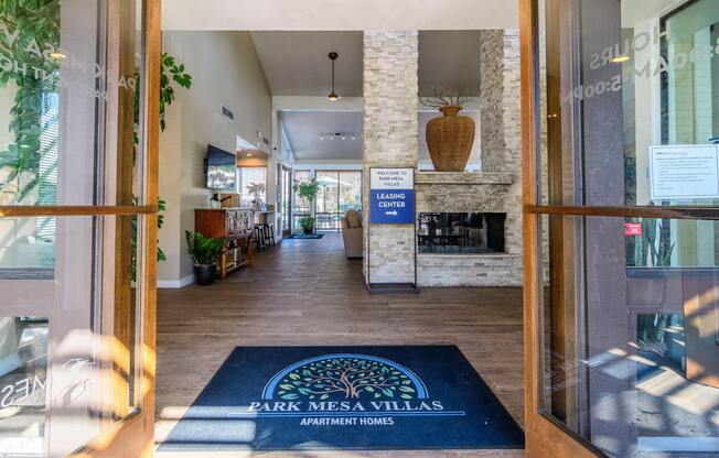 The image shows the entrance to Park Mesa Villas Apartment Homes with a blue doormat and a sign.