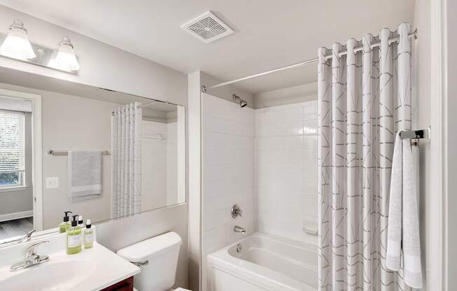 A white bathroom with a bathtub.