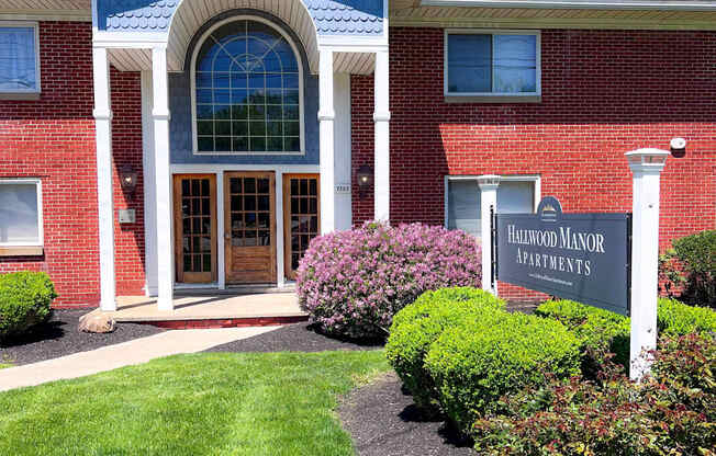 The front of a building with a sign that says "Hollywood Manor Apartments".