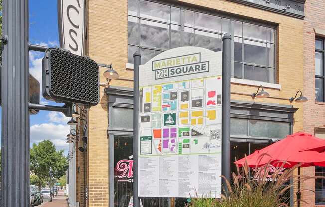 A sign for Marietta Square is displayed on a pole in front of a building.