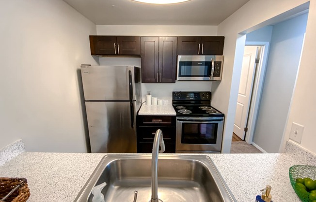 Modern kitchen with stainless steel appliances at Camelot East Apartments, Ohio