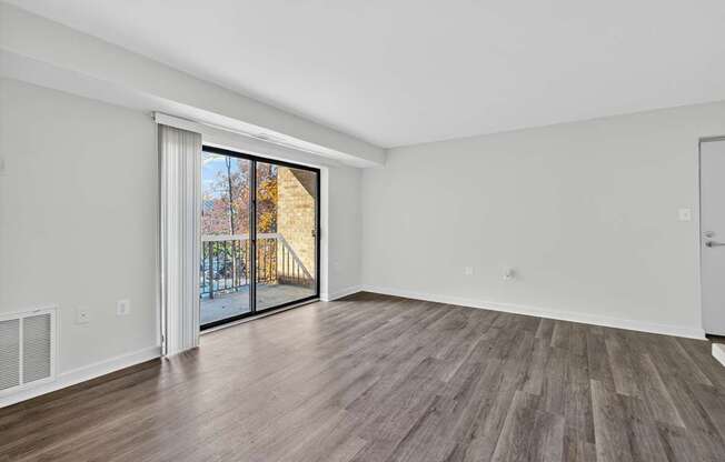 A room with a sliding glass door leading to a balcony.