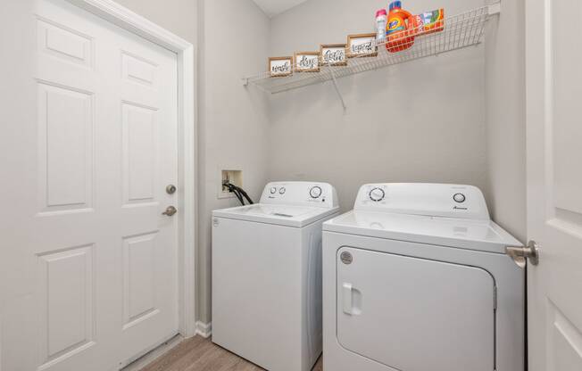 a washer and dryer in a laundry room with a white door