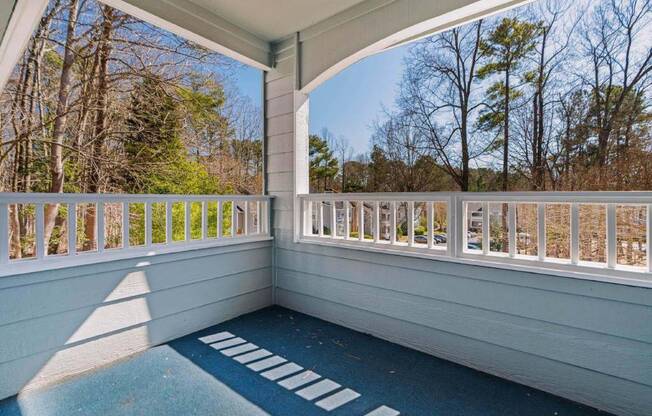 a covered porch with a view of the woods