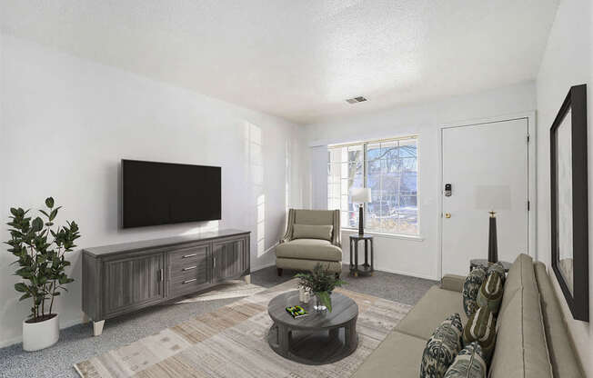 A living room with a flat screen TV, a sofa, and a coffee table at Newport Village Apartments, Portage, MI