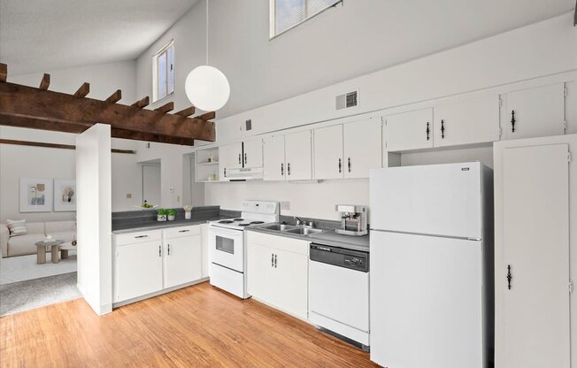 a kitchen with white cabinets and a wood floor