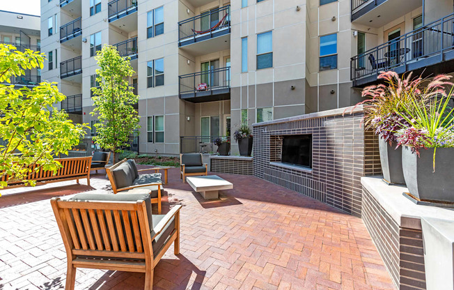 A patio with a bench and a fireplace in front of a building.
