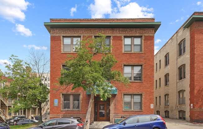 a red brick building with a tree in front of it