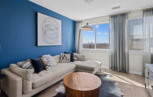 a living room with a blue wall and a couch and a table at Alton Jefferson Park, Denver, 80211