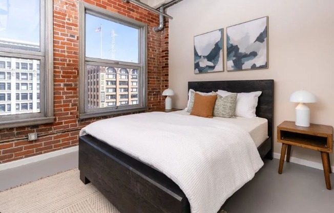 a bedroom with a bed and a brick wall