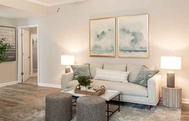 a living room with a couch and two paintings on the wall