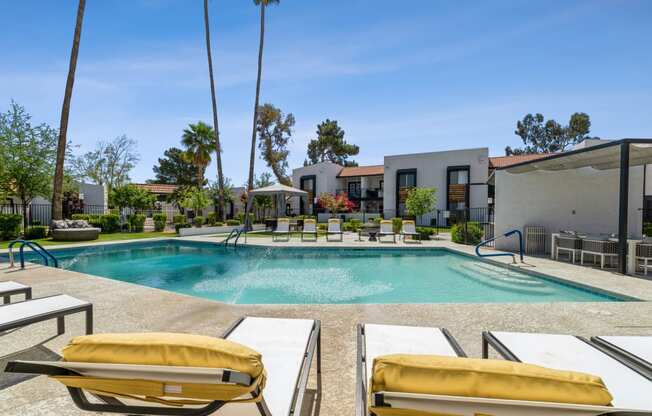 a swimming pool with lounge chairs and a gazebo