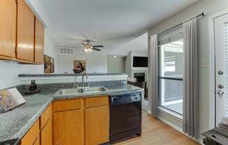 A kitchen with wooden cabinets and a granite countertop.