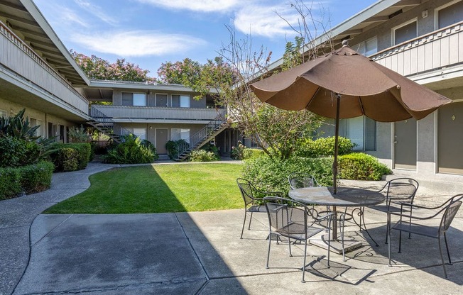 a patio with a table and chairs and an umbrella