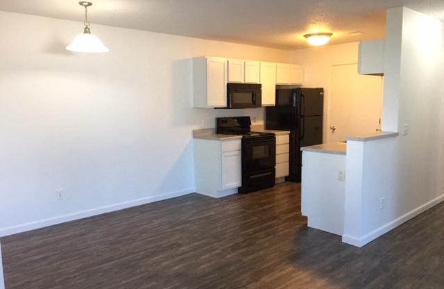 spacious dining room, bright white clean cabinets, wood flooring, premium countertops and appliances at regency apartments in Bettendorf Iowa
