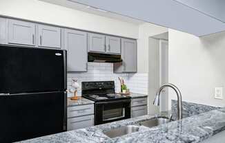 Kitchen with granite counter tops and black appliances