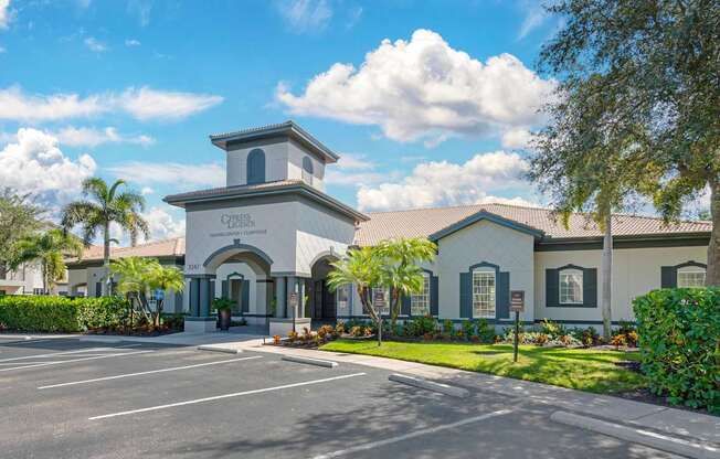 A white building with a tower and a sign that says