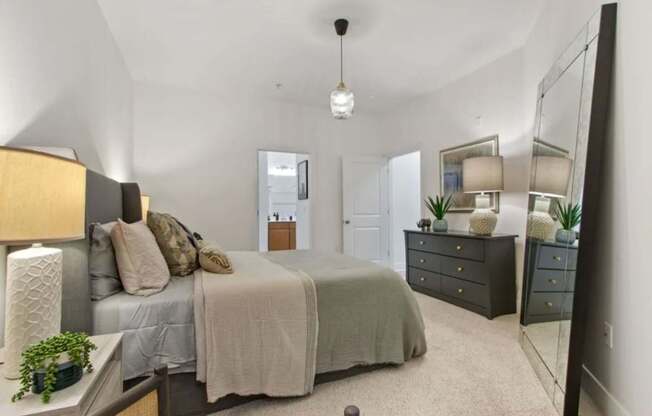 A bedroom with a bed, dresser, and mirror.