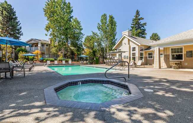 A small pool with a hot tub in the middle of a patio.