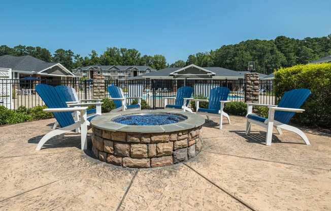 a fire pit with blue chairs and chairs around it