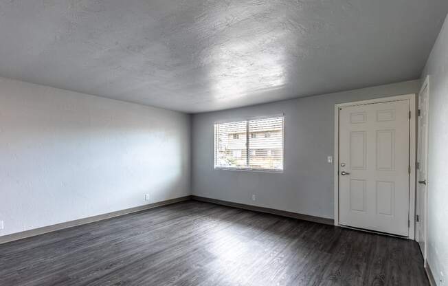 the living room of an empty house with a white door